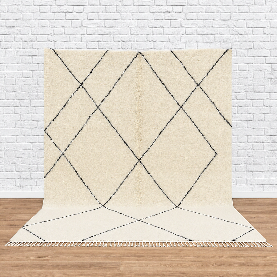 Beige rug with black geometric pattern on a wooden floor and white brick wall background