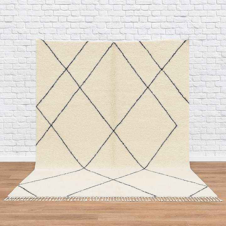 Beige rug with black geometric pattern on a wooden floor and white brick wall background