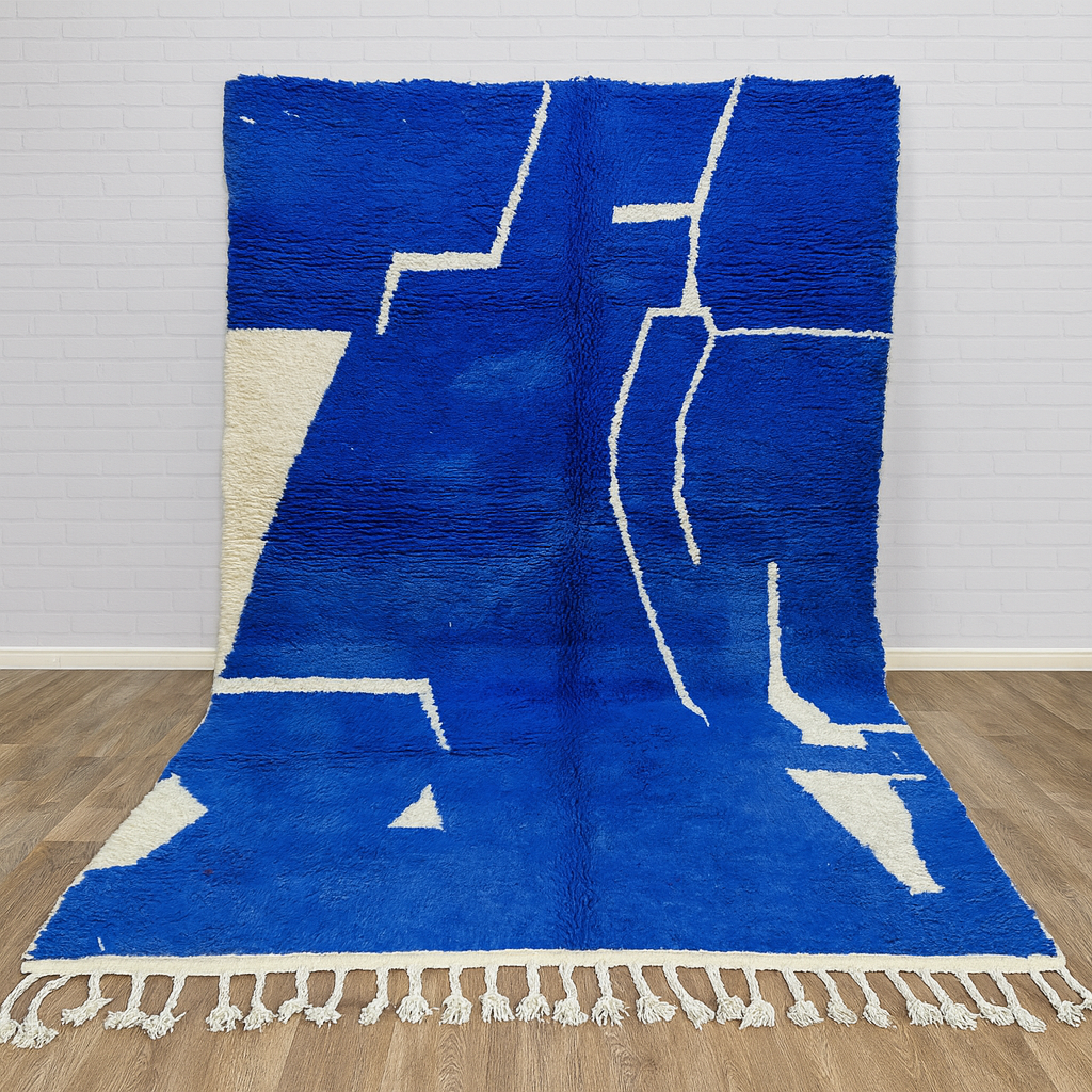 Blue and white geometric patterned rug on a wooden floor with a light gray wall background