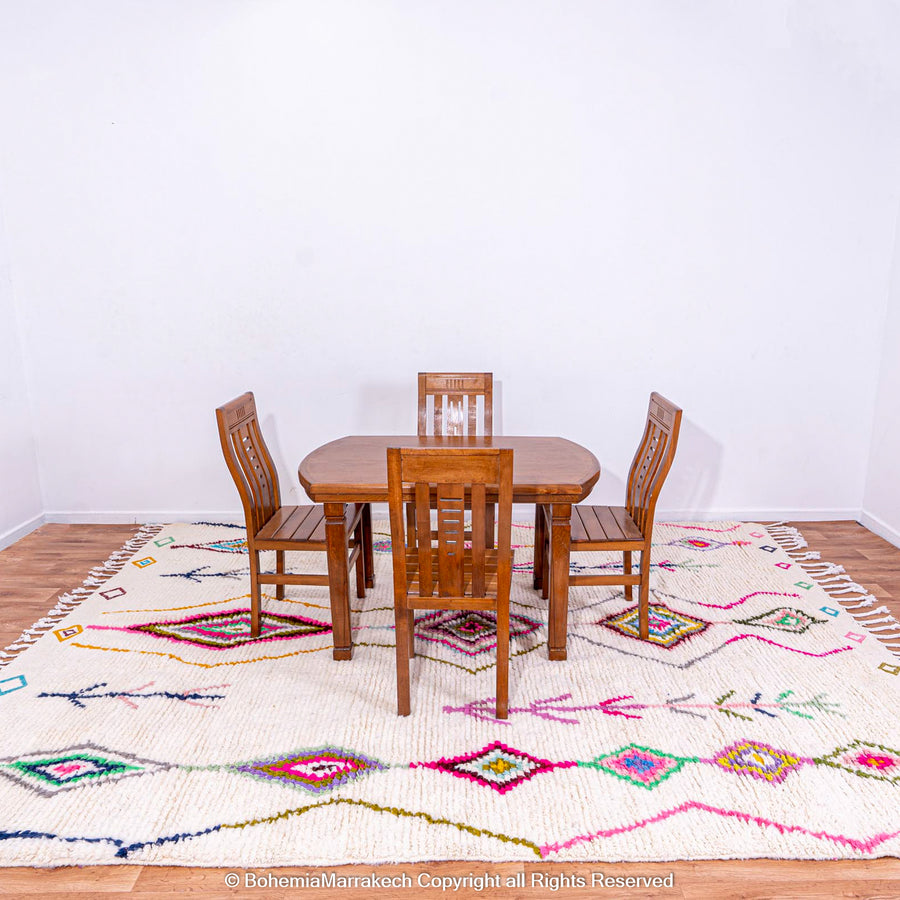 Colorful Moroccan Berber Rug with Azilal Diamond Motifs under dining table, vibrant fuchsia, turquoise on ivory, 100% wool.