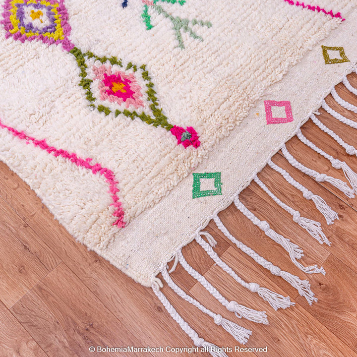 Colorful Moroccan Azilal rug with diamond motifs; features fuchsia, turquoise, yellow on ivory. Handwoven 100% wool.