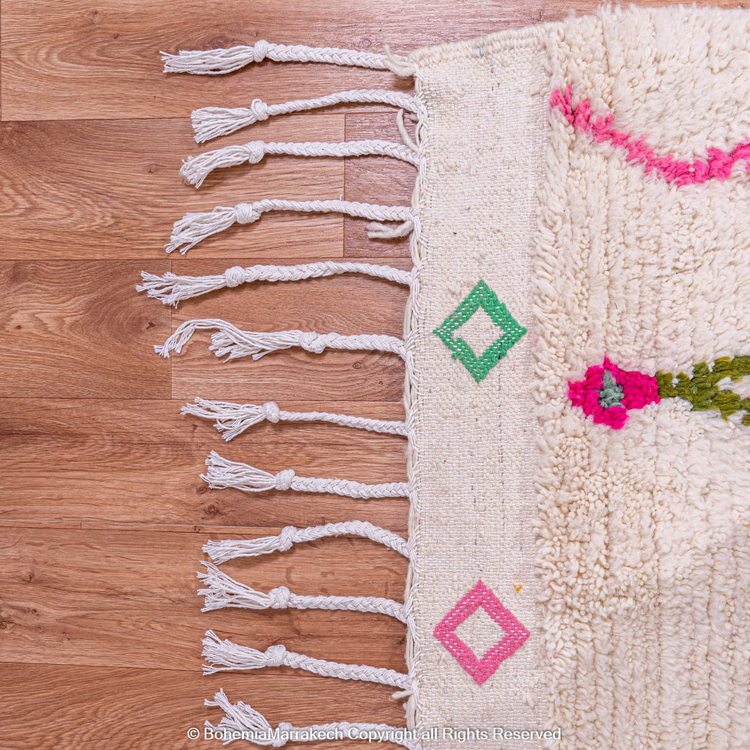 Handwoven Moroccan Berber rug with Azilal diamond motifs in vibrant colors on an ivory background.