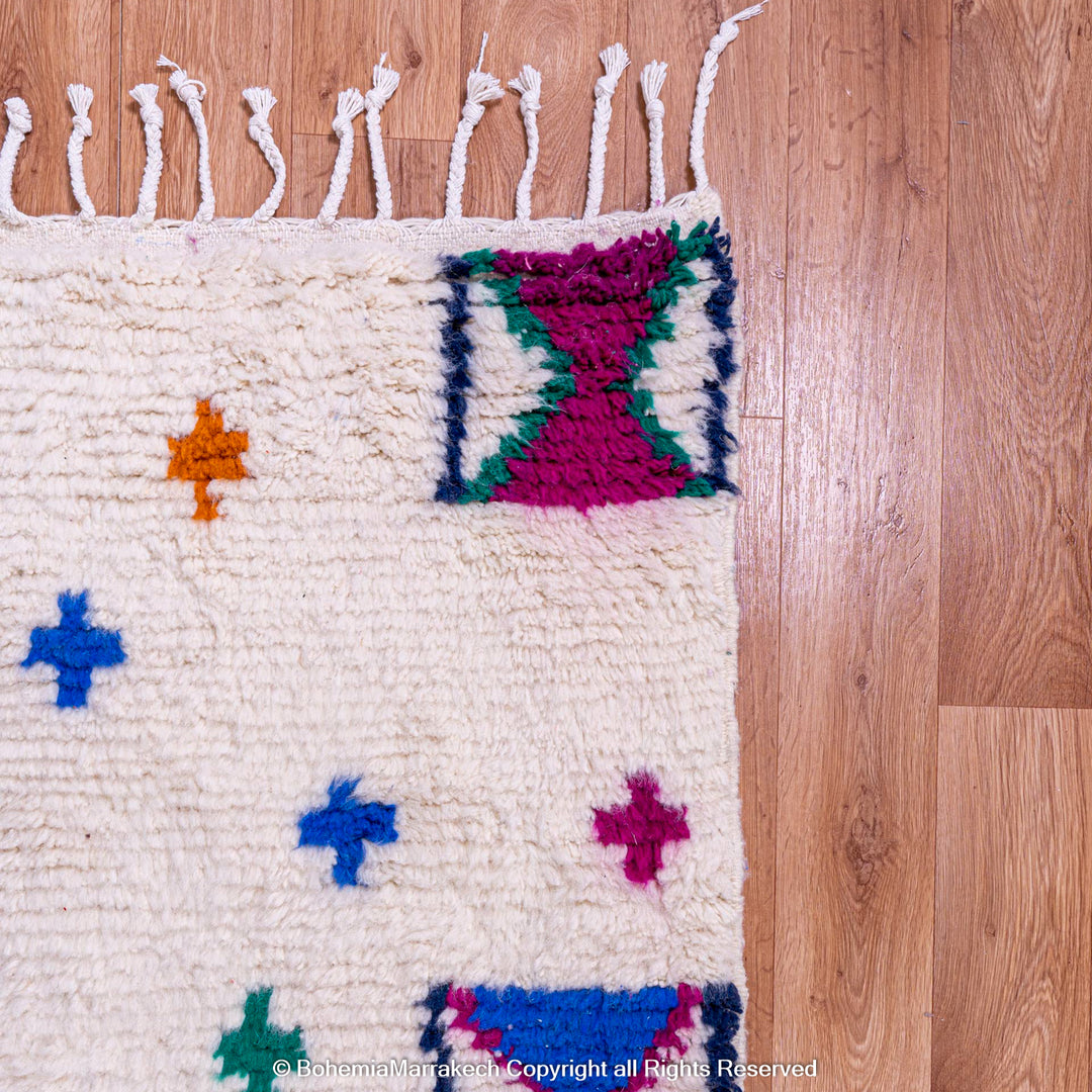 Colorful Moroccan Berber rug with traditional X and cross symbols on ivory base, handwoven wool, ideal for eclectic spaces.