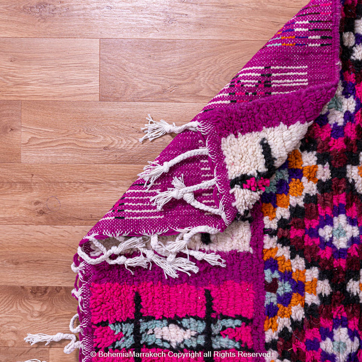 Handmade Boujad Moroccan rug in pink and purple with tribal motifs, crafted from 100% wool by Berber artisans. Perfect area or shag rug.