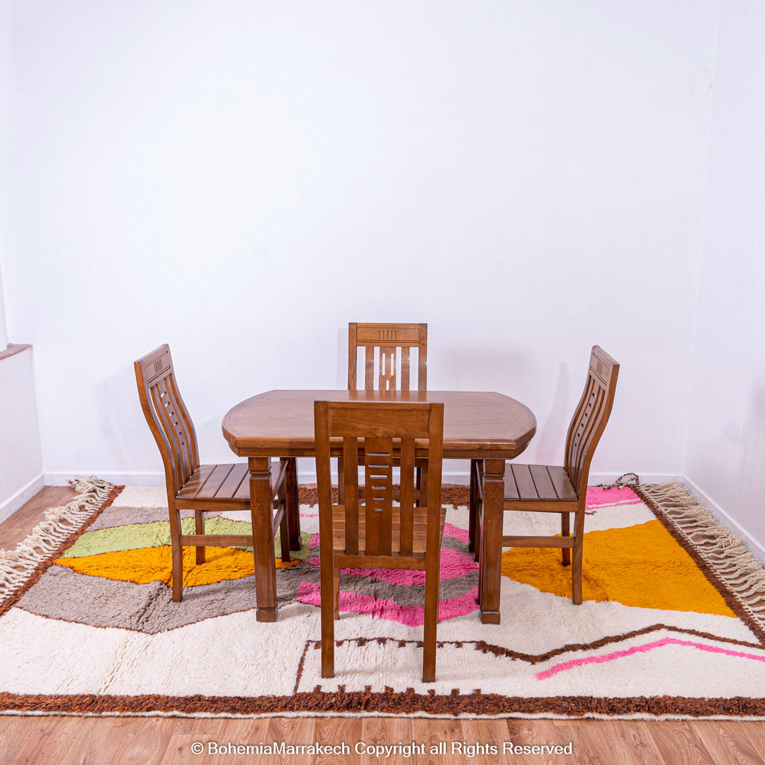 Handmade colorful Moroccan rug with pink, yellow, brown, and green geometric patterns on white wool