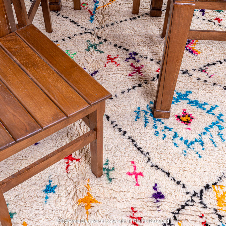 White Moroccan wool rug with multicolor tribal symbols and diamond pattern