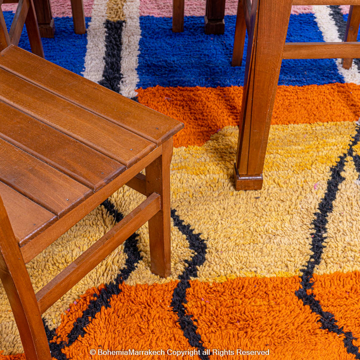 Handmade multicolor Moroccan wool rug with abstract geometric shapes in orange, blue, pink, and brown tones