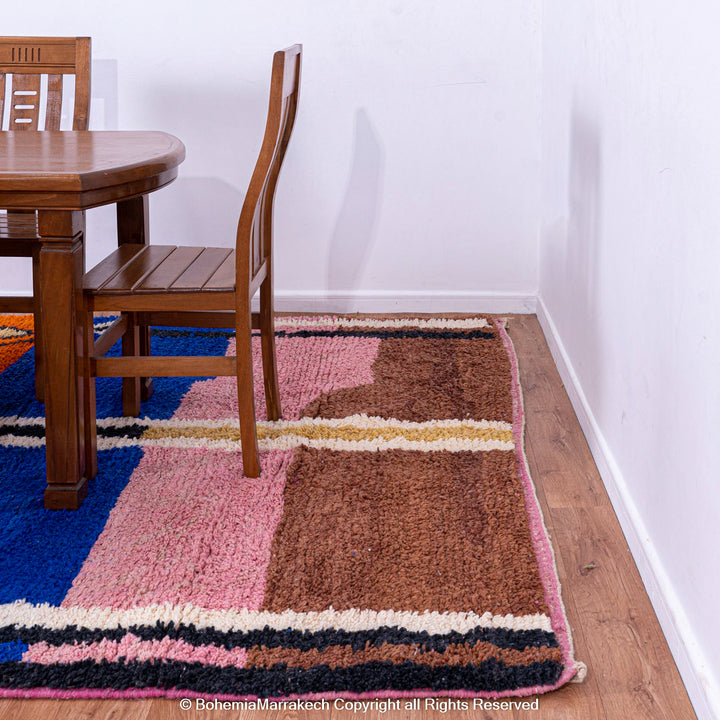 Handmade multicolor Moroccan wool rug with abstract geometric shapes in orange, blue, pink, and brown tones