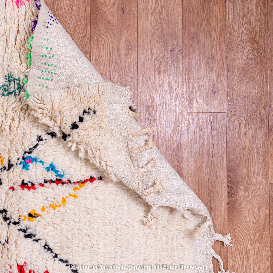 White Moroccan wool rug with multicolor tribal symbols and diamond pattern
