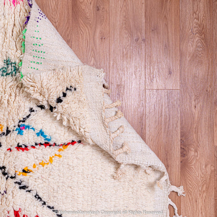 White Moroccan wool rug with multicolor tribal symbols and diamond pattern