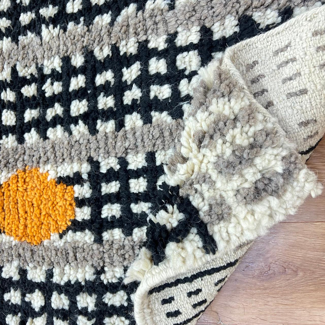 Handmade Moroccan wool rug with black grid and amber dot design. Soft plush texture, modern style, and artisan crafted.