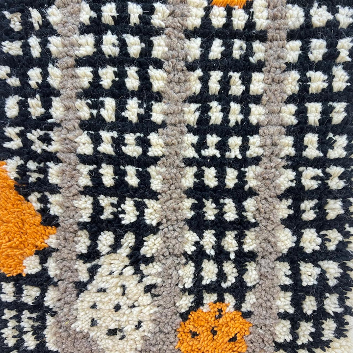 Handmade Moroccan wool rug with black grid and amber dot design. Soft plush texture, modern style, and artisan crafted.