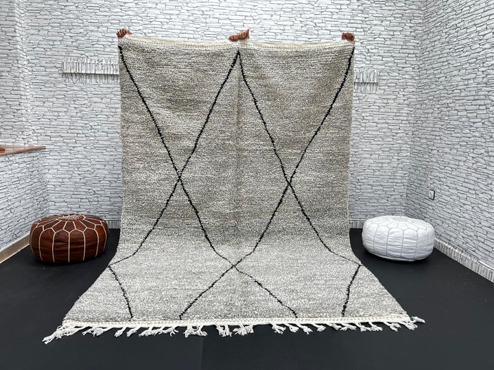Handwoven gray Moroccan wool rug with black diamond pattern and fringes, handmade by Berber women in the Atlas Mountains