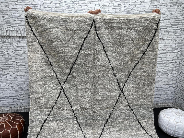 Handwoven gray Moroccan wool rug with black diamond pattern and fringes, handmade by Berber women in the Atlas Mountains