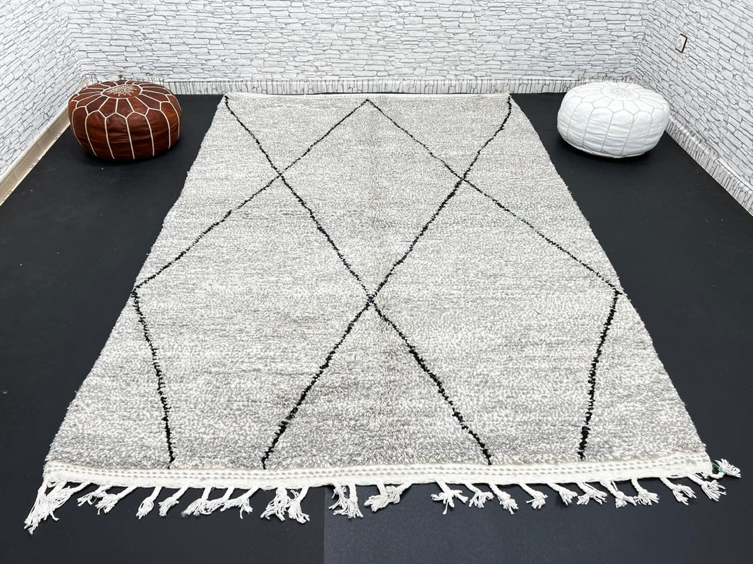 Handwoven gray Moroccan wool rug with black diamond pattern and fringes, handmade by Berber women in the Atlas Mountains