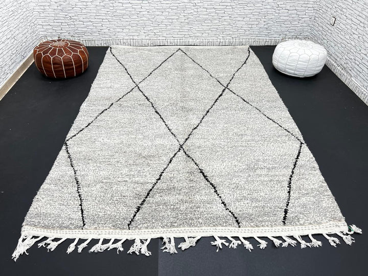 Handwoven gray Moroccan wool rug with black diamond pattern and fringes, handmade by Berber women in the Atlas Mountains