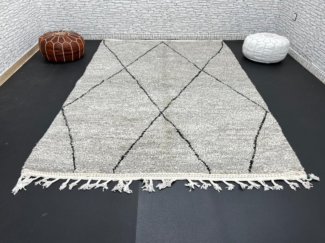 Handwoven gray Moroccan wool rug with black diamond pattern and fringes, handmade by Berber women in the Atlas Mountains