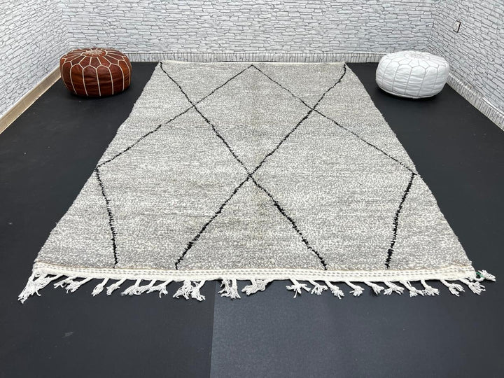 Handwoven gray Moroccan wool rug with black diamond pattern and fringes, handmade by Berber women in the Atlas Mountains