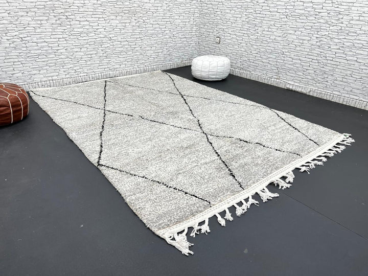 Handwoven gray Moroccan wool rug with black diamond pattern and fringes, handmade by Berber women in the Atlas Mountains