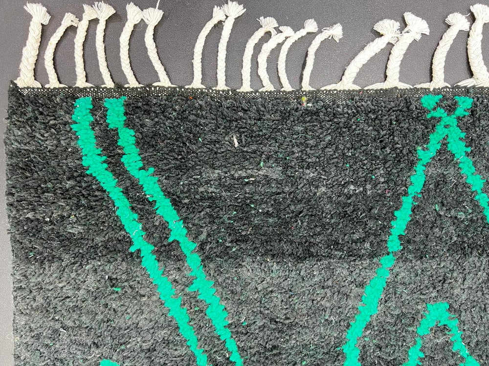 Handwoven green Moroccan wool runner rug with geometric line patterns and black gradient base.