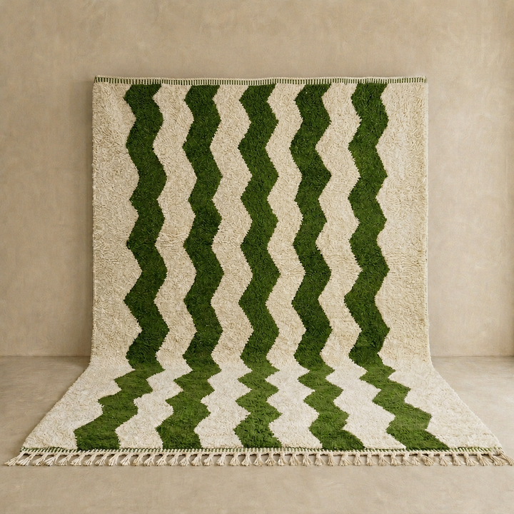 Large handmade Moroccan wool rug with ivory wool base and dark green wavy stripe pattern, displayed on a wooden floor.