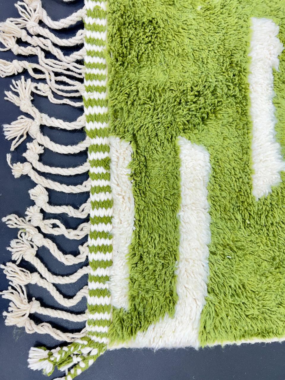 Handmade Moroccan runner rug with vibrant green and white abstract design, crafted from natural wool by Berber artisans.