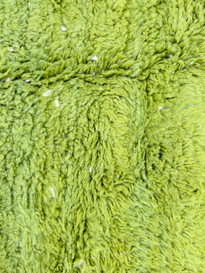 Handmade Moroccan runner rug with vibrant green and white abstract design, crafted from natural wool by Berber artisans.