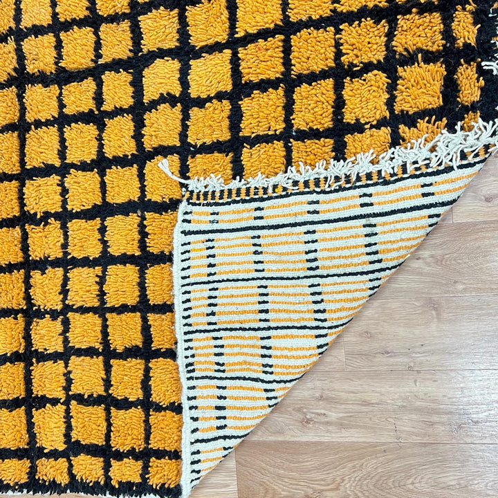 Handmade Moroccan wool rug with bold yellow and black grid design. Soft plush texture, modern style, and ethically crafted in Morocco.