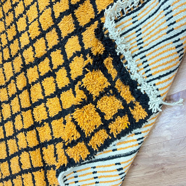 Handmade Moroccan wool rug with bold yellow and black grid design. Soft plush texture, modern style, and ethically crafted in Morocco.