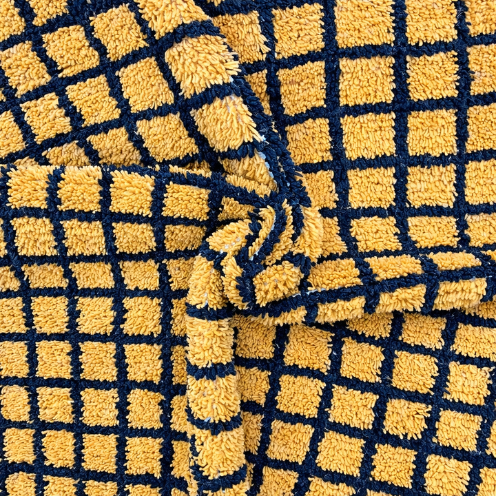 Handmade Moroccan wool rug with bold yellow and black grid design. Soft plush texture, modern style, and ethically crafted in Morocco.
