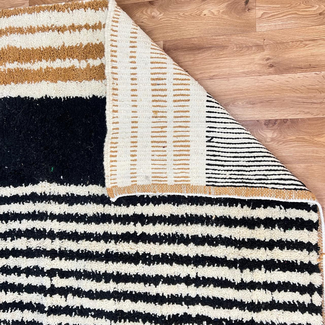 Handmade Moroccan wool runner rug with modern geometric design in burnt orange, black, gray, and ivory, perfect for hallway or entryway.