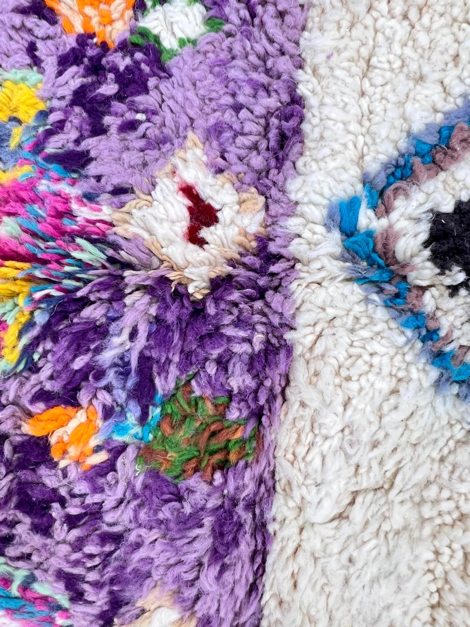 Handmade round Moroccan wool rug in white and brown with colorful Berber pattern