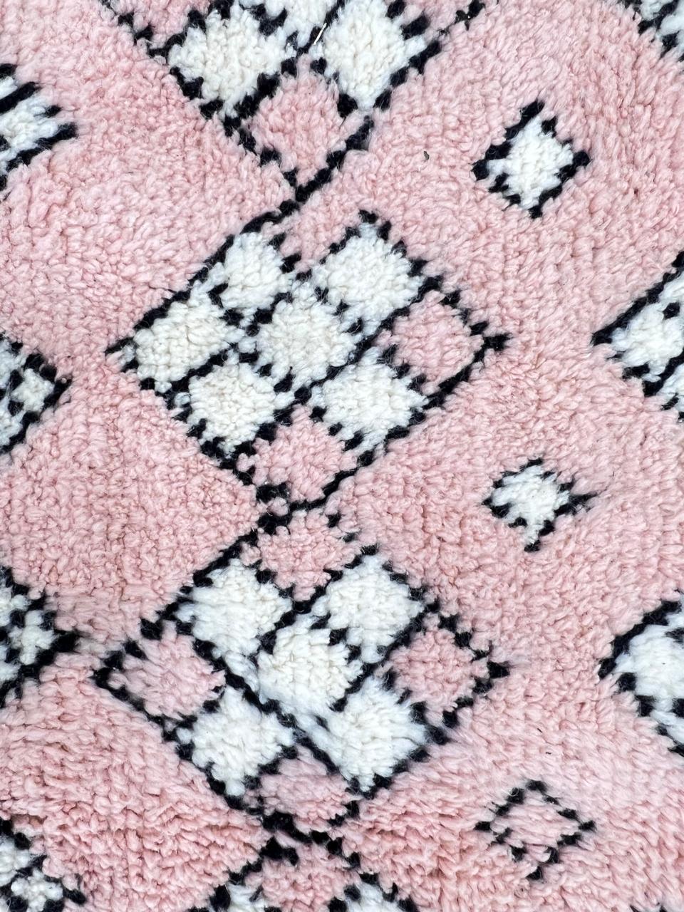 Round pink Moroccan wool rug with ivory diamond Berber motifs and fine black geometric lines, handmade Amazigh wool area rug.