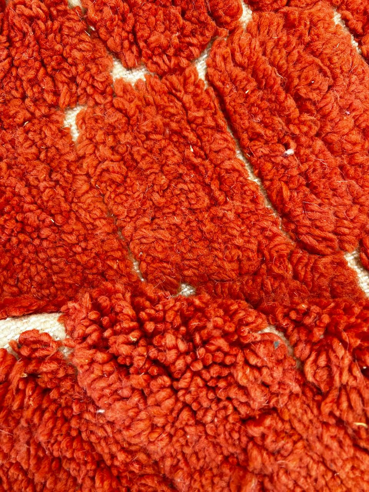 Handmade round Moroccan wool rug with rich textured surface and modern minimalist design.