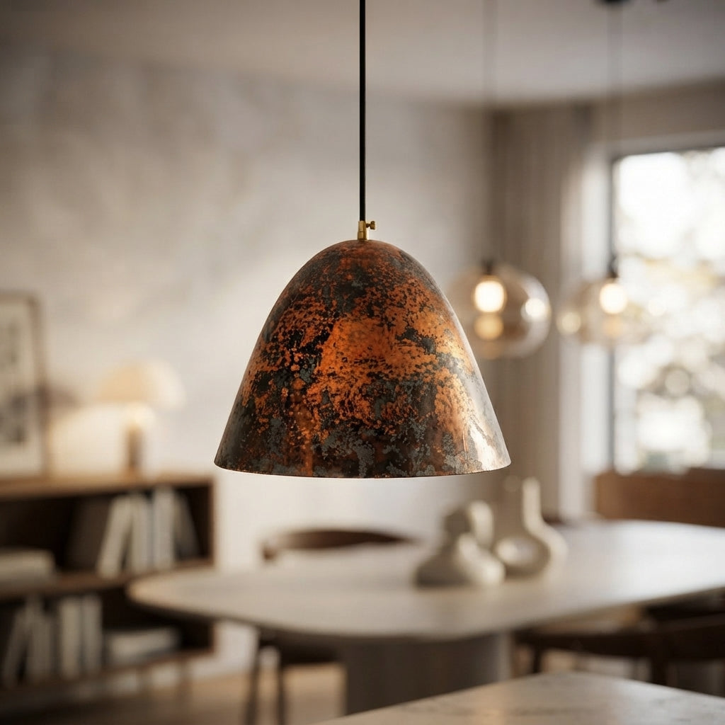 Handmade aged copper dome pendant light with a dark distressed patina in a modern industrial interior.