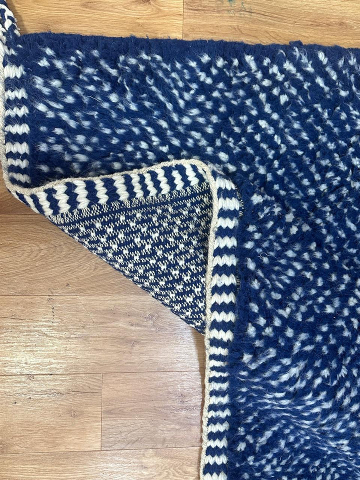 Close-up of deep indigo blue Moroccan wool rug with natural ivory speckled texture