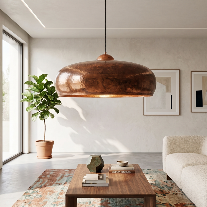Handmade hammered copper pendant light with a wide Moroccan dome design, displayed in a modern luxury living room.