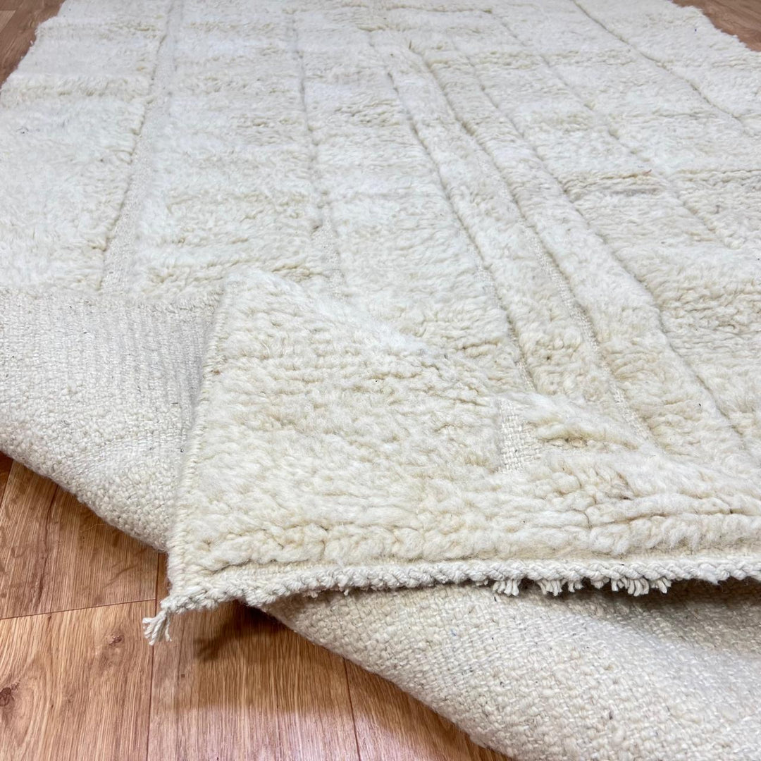 Handmade Moroccan wool runner rug in cream with raised carved geometric design and fringed ends