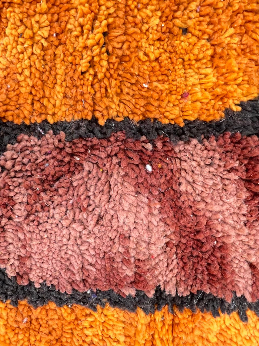 Handmade round abstract Moroccan wool rug in red, orange, and green color blocks