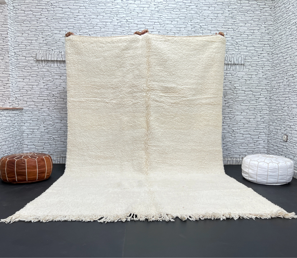 White textured rug on a black floor with a white brick wall background