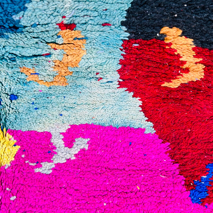 Vintage Moroccan abstract rug with bold boho colors; handwoven by Berber women. Features vibrant red, blue, pink, and mustard tones.