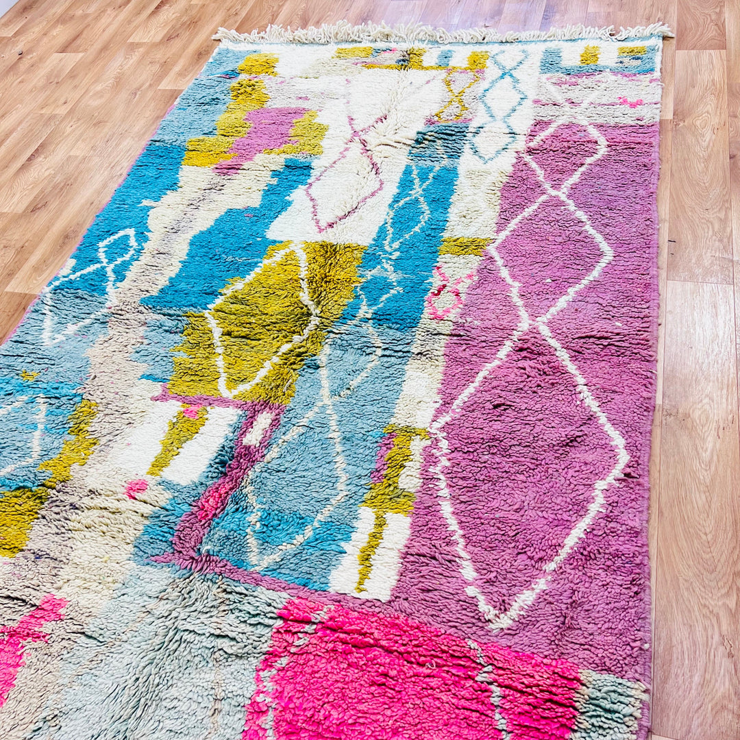 Vintage Moroccan Berber rug 8.5x5.3 ft in pink and blue with abstract diamond motifs, handwoven with natural wool.