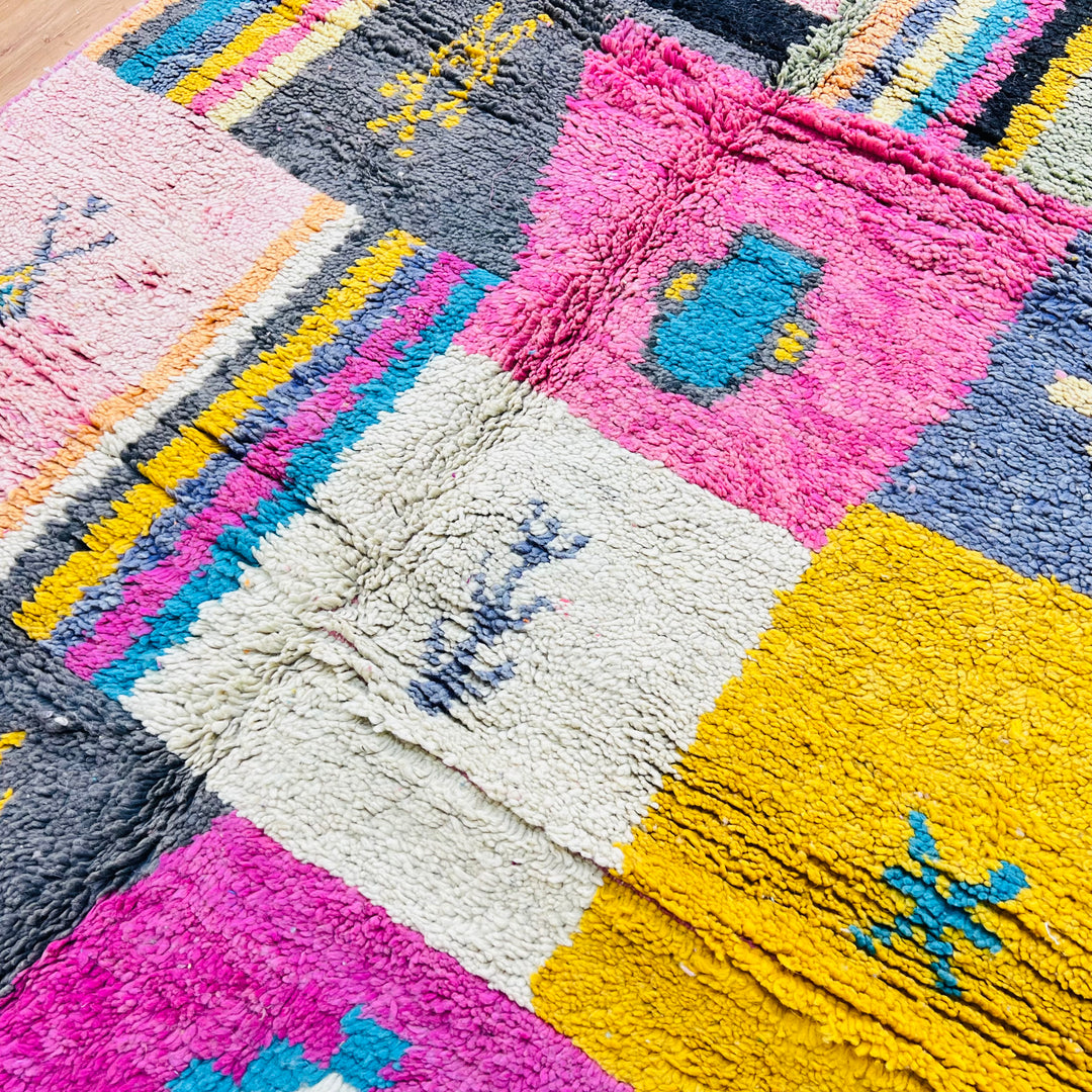 Colorful vintage Moroccan Berber rug with patchwork design in pink, yellow, and blue tones. Hand-knotted wool carpet.