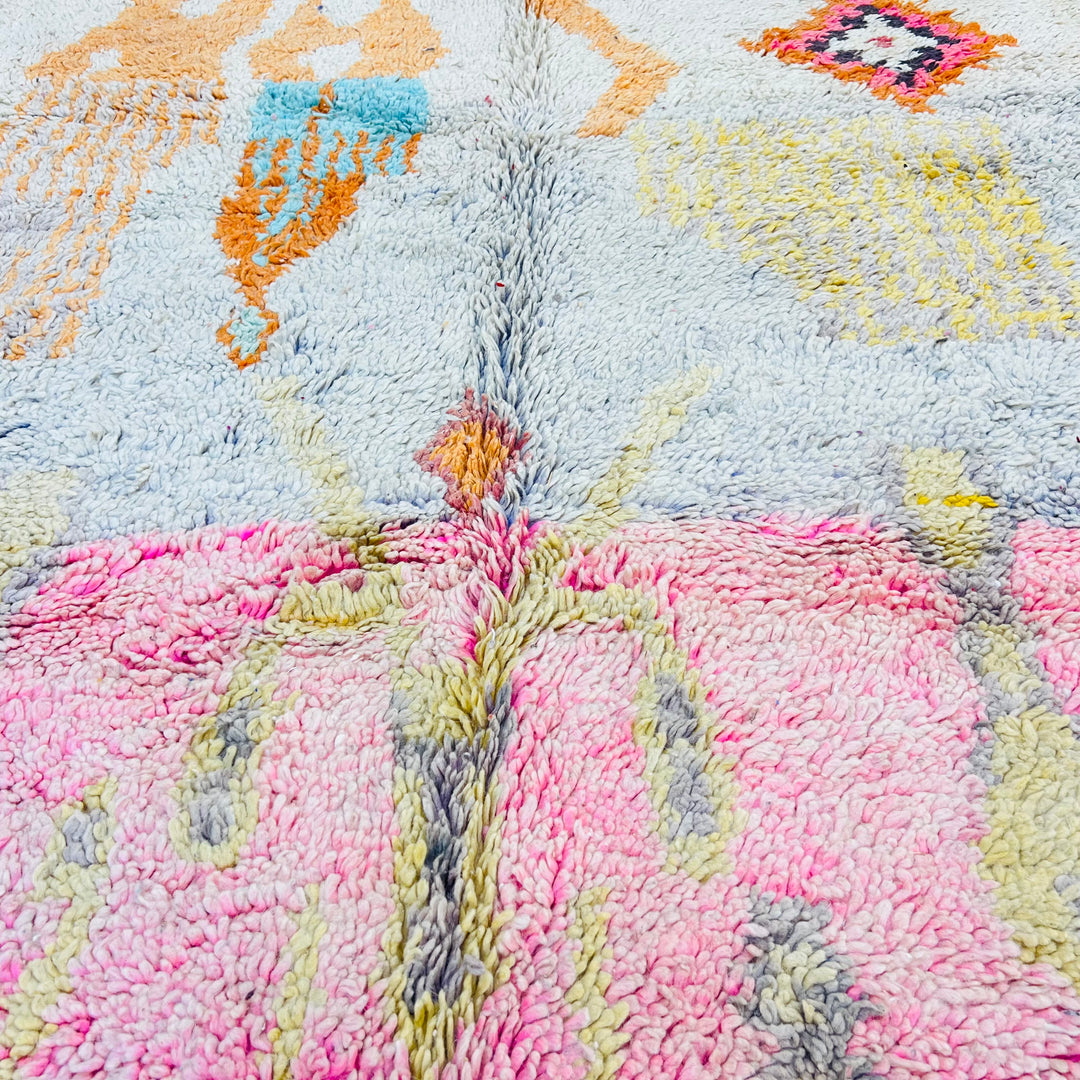 Close-up of a handmade vintage Moroccan wool rug with colorful tribal patterns and soft pastel tones.