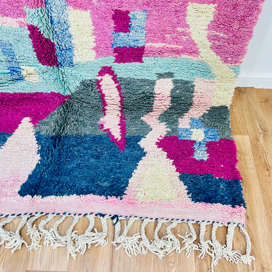Colorful Moroccan Berber rug with geometric patterns in pink, blue, and green, 8x5 ft, handwoven with 100% wool, perfect for boho interiors.