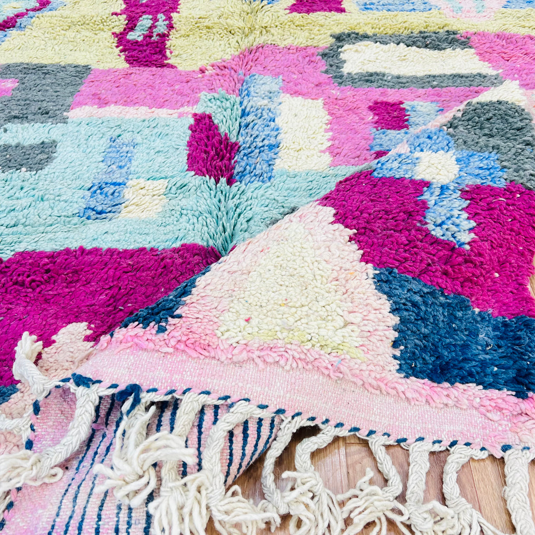 Colorful Moroccan Berber rug with geometric patterns in pink, blue, yellow, handwoven 8x5 ft, perfect for boho-style interiors.