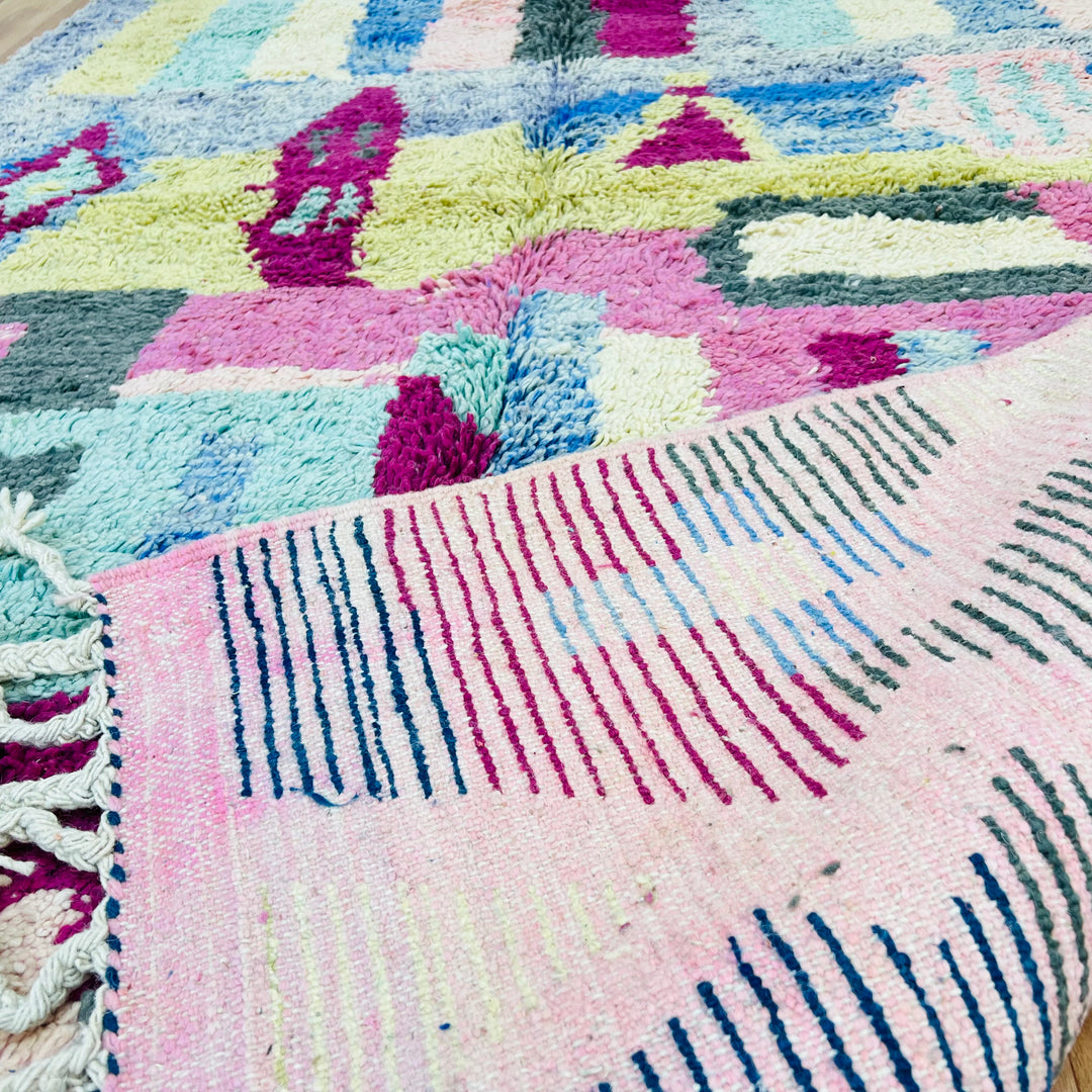 Colorful Moroccan Berber rug with geometric patterns in pink, blue, yellow, and green stripes; handmade wool rug 8x5 ft.