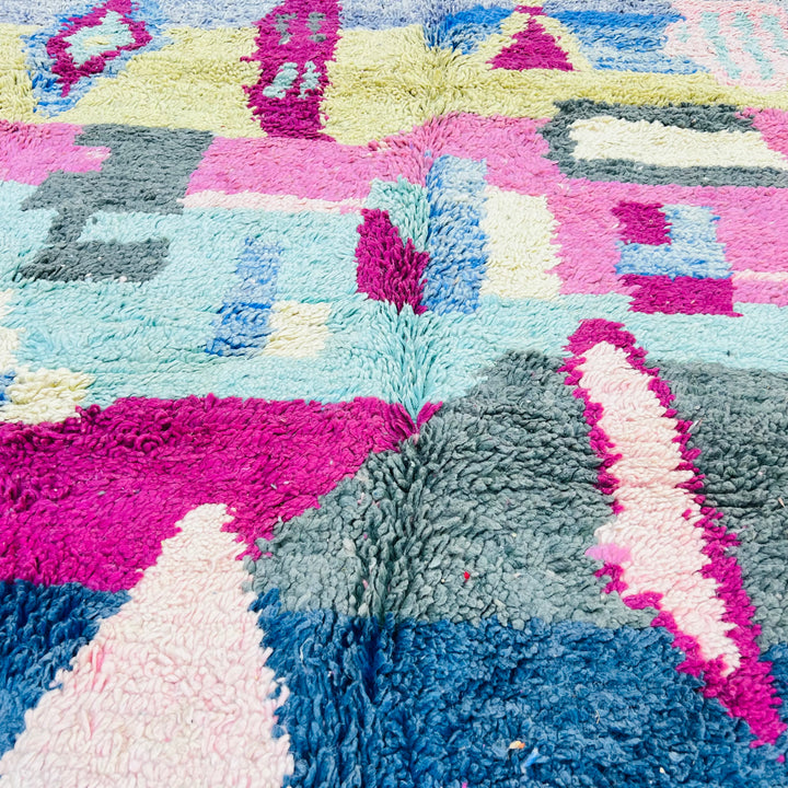 Colorful Moroccan Berber rug with vibrant pink, blue, yellow, and green geometric patterns. Handwoven 8x5 ft vintage wool area rug.