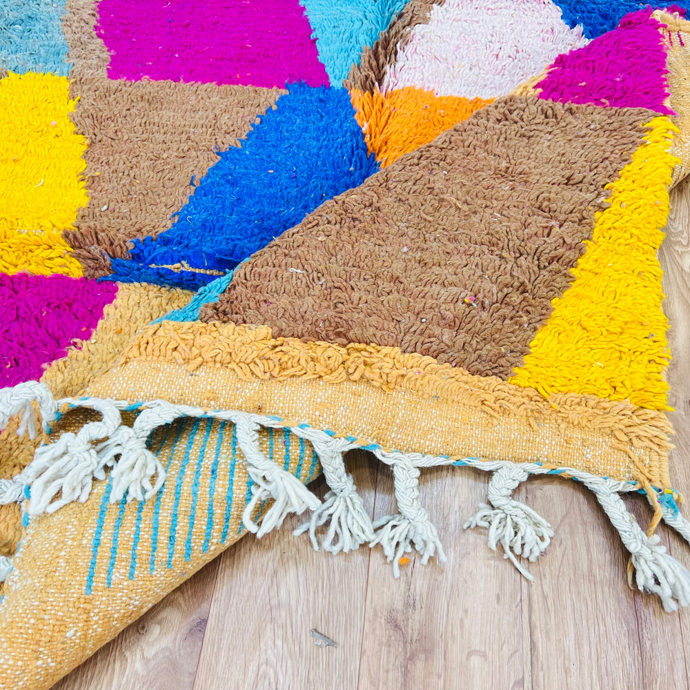 Vintage Moroccan rug with vibrant geometric design in pink, blue, and yellow, handmade from wool by Berber women, 8.2x5 ft.