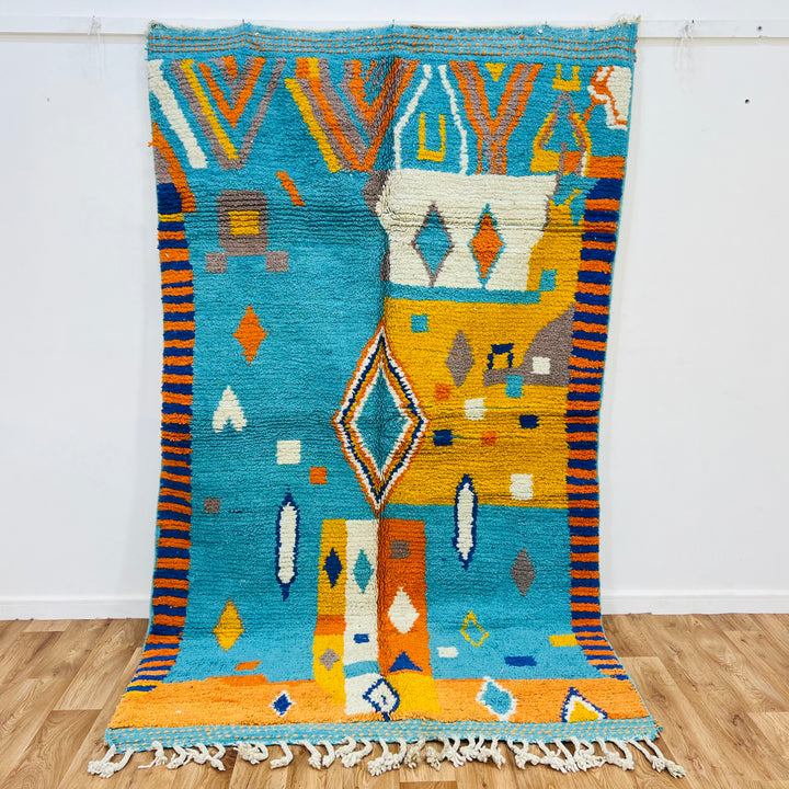 Handmade Moroccan Berber rug with turquoise blue and sunset orange, geometric patterns, made of 100% wool. Perfect for boho decor.